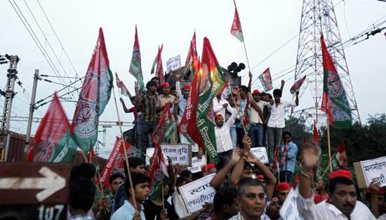 Samajwadi Party activists hold party flags and block a railway track during a protest in Allahabad, India, Thursday, Sept. 20, 2012.