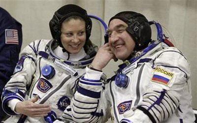 The International Space Station (ISS) crew members U.S. astronaut Tracy Caldwell-Dyson (L) and Russian cosmonaut Alexander Skvortsov talk after putting on space suits at Baikonur Cosmodrome April 2, 2010. REUTERS/Sergei Karpukhin