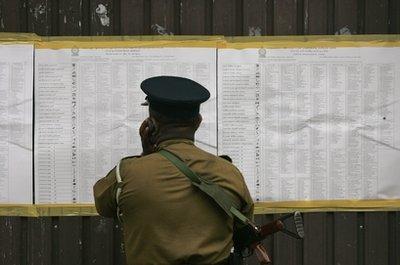A Sri Lankan police officer goes through election notices as he stands guard at a polling station in Colombo, Sri Lanka, Thursday, April 8, 2010. Sri Lankans voted Thursday for a new Parliament that will decide how to ensure peace and development after decades of civil war, with President Mahinda Rajapaksa seeking to expand his political dominance after winning re-election. (AP Photo/Eranga Jayawardena) 