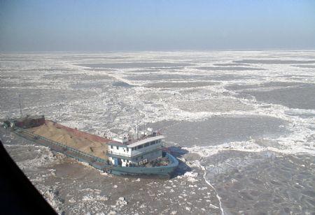 The video grab taken on Jan. 13, 2010 shows a ship is trapped by sea ice off the coast of Binzhou City of east China's Shandong Province. A total of six crewmen on the ship were rescued safely by a helicopter from Chinese North Sea relief flight team on Wednesday. (Xinhua Photo)
