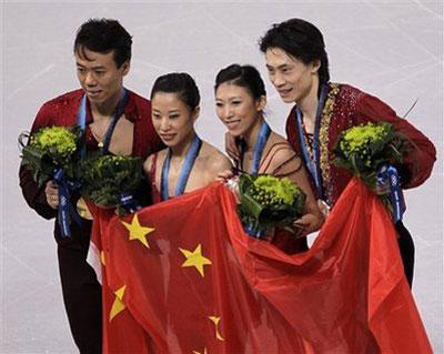 Gold medallists Shen Xue and Zhao Hongbo of China, left, and silver medallists Pang Qing and Tong Jian of China, right, pose for photographers with the national flag of China, during the victory ceremony, following the pairs free program figure skating competition at the Vancouver 2010 Olympics in Vancouver, British Columbia, Monday, Feb. 15, 2010.  (AP Photo/David J. Phillip)
