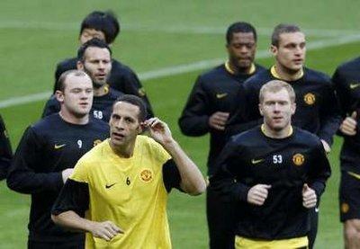 Manchester United's Wayne Rooney (L) and Rio Ferdinand (2nd L) warming up during a training session in Munich March 29, 2010. Bayern Munich are set to play Manchester United in a Champions League quarter-final soccer match on Tuesday.REUTERS/Michaela Rehle (GERMANY - Tags: SPORT SOCCER)