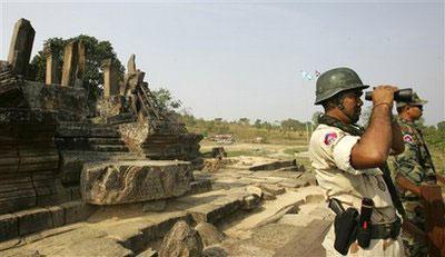 In this March 13, 2009, file photo a Cambodian soldier looks at the Thai border through binoculars from an entrance of Cambodia's Preah Vihear temple near the Cambodian-Thai border. (AP Photo/Heng Sinith)
