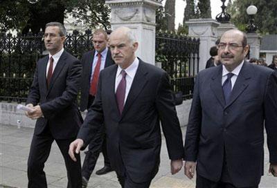 Greek Prime Minister George Papandreou, center, leaves Greece's Presidential Mansion after meeting President Karolos Papoulias in central Athens, Greece, on Wednesday, March 3, 2010. (AP Photo/Petros Giannakouris)