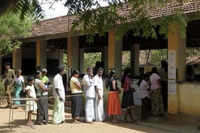 Sri Lankan voters stand in a queue outside a polling station near Hambantota Sri Lanka, Thursday, April 8, 2010. (AP Photo/Manish Swarup)