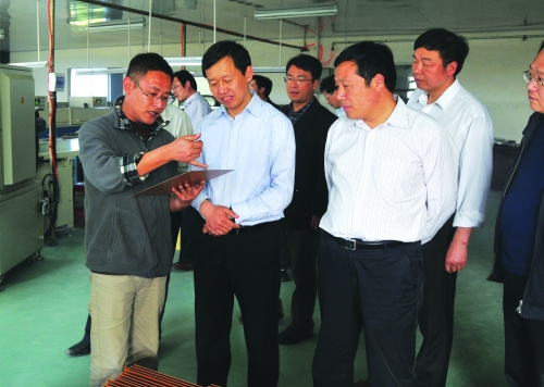 新野县委书记金浩(左二)在立新电子公司调研新野县县长常英敏(左二)