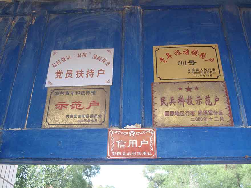 彭阳县古城镇任河村村支书杨生科家的大门上挂了大大小小5块牌子