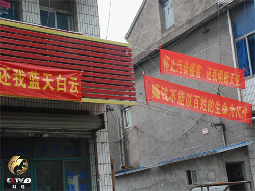 　　村里“停止污染侵害，还我明朗天空”的条幅挂在路边