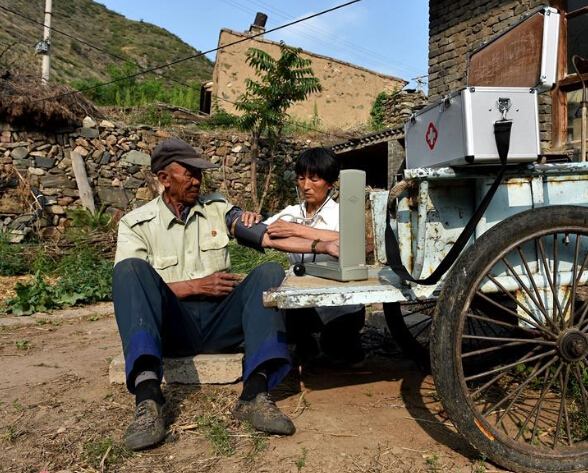 在山西省代县两家店村，刘桂珍在一位村民家中为他测量血压。
