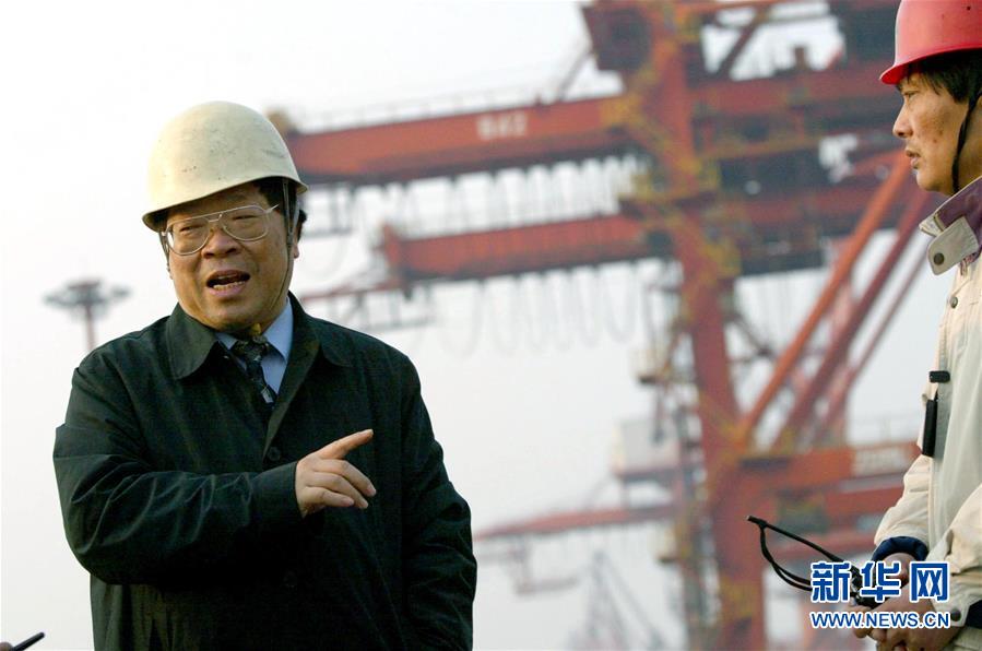 包起帆（左）来到上海港码头，向工人了解春节期间集装箱装运情况（2004年1月28日摄）。