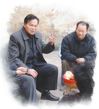 冉绍之（左）在做移民动员工作。