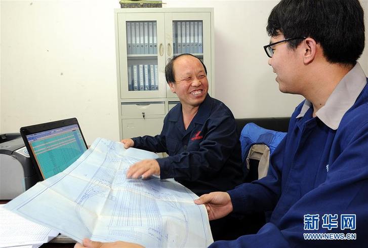 巨晓林（左）在计算机前与徒弟张建观看设计施工图（2012年8月16日摄）。新华社记者 何俊昌 摄