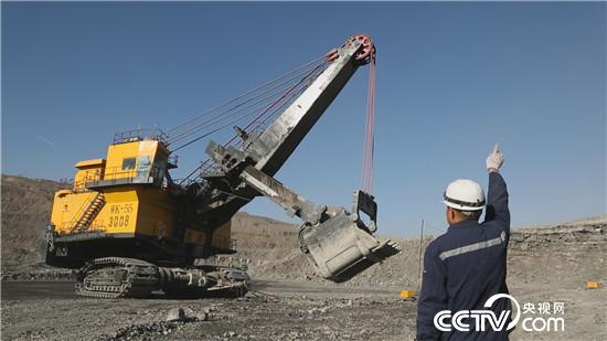 中煤与太重联合研发的国产第一个55立方米挖掘机（WK-55电铲）在现场的工人指挥下工作