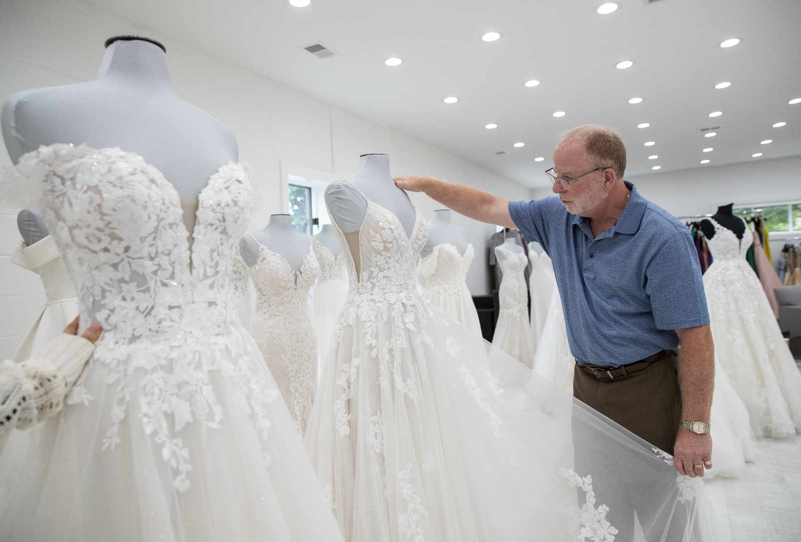 Steve Lang, president of the American Bridal and Prom Industry Association, who is also CEO of U.S. brand Mon Cheri, looks at a bridal dress at his company