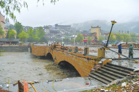 强降雨造成汶川县水磨镇寿溪河上的桥梁受损。 新华社发