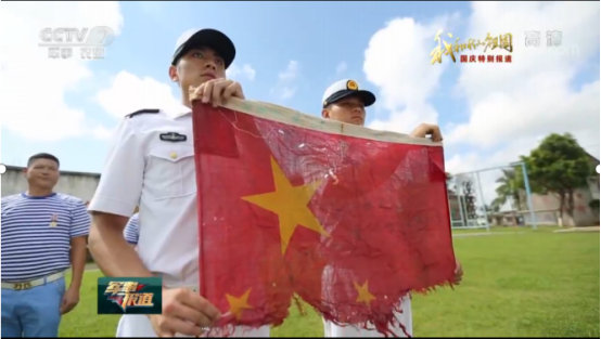 　　南沙渚碧礁第一面国旗移交到新一代守礁官兵手中（《军事报道》截图）