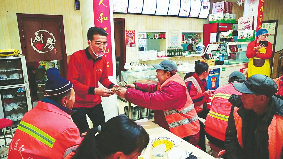 The picture shows Ren Gang delivering breakfast to sanitation workers. Photo by Yang Hui