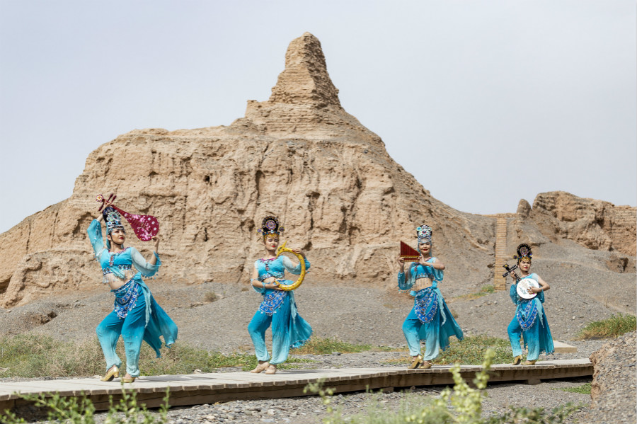 Dancers hold a live broadcast while performing local folk dances at cultural heritage sites in Kucha of Aksu Prefecture, northwest China