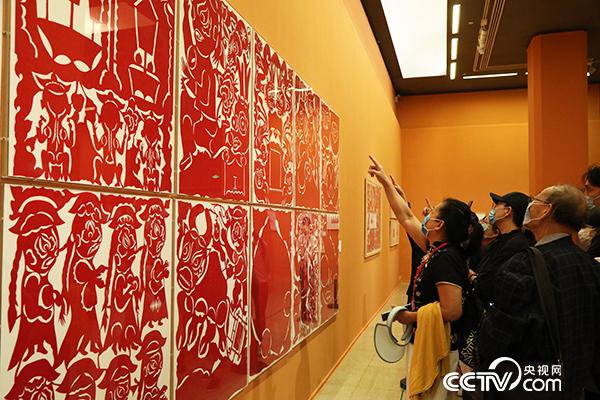 观众参观“以美扶智——中国美术馆脱贫攻坚美术作品展”中的剪纸艺术品