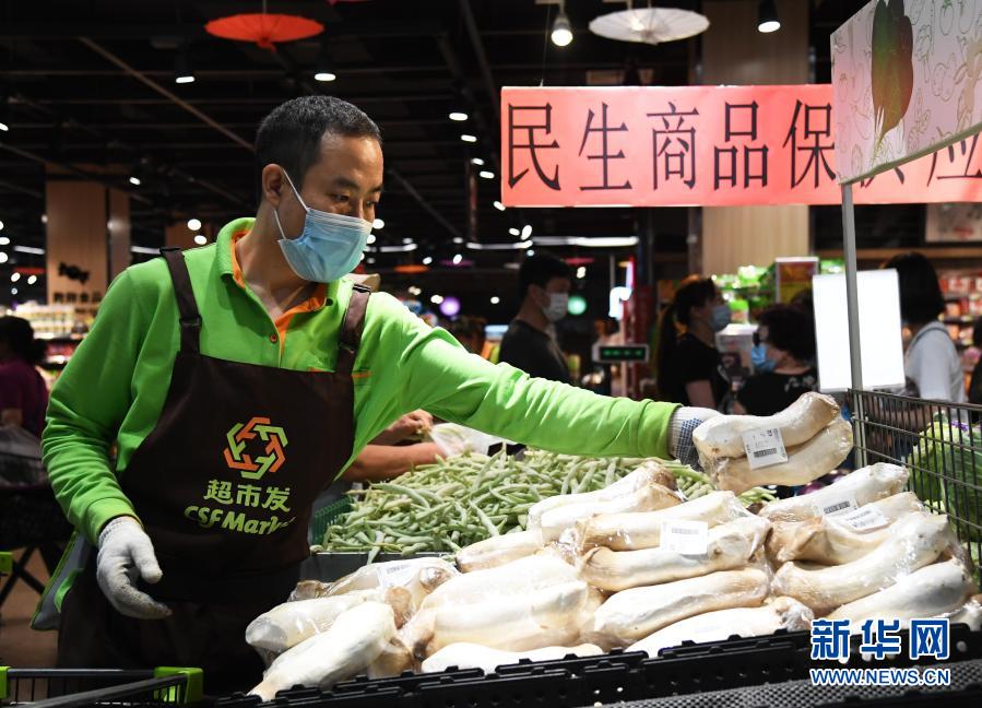 6月14日，在北京市海淀区的超市发双榆树店，工作人员将包装好的蔬菜码放到货架。新华社记者 任超 摄