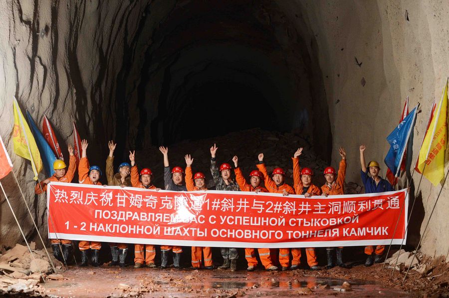 Workers pose for group photos to celebrate the completion of Qamchiq Tunnel, part of the Angren-Pap railway line, in Uzbekistan, Feb. 27, 2016.