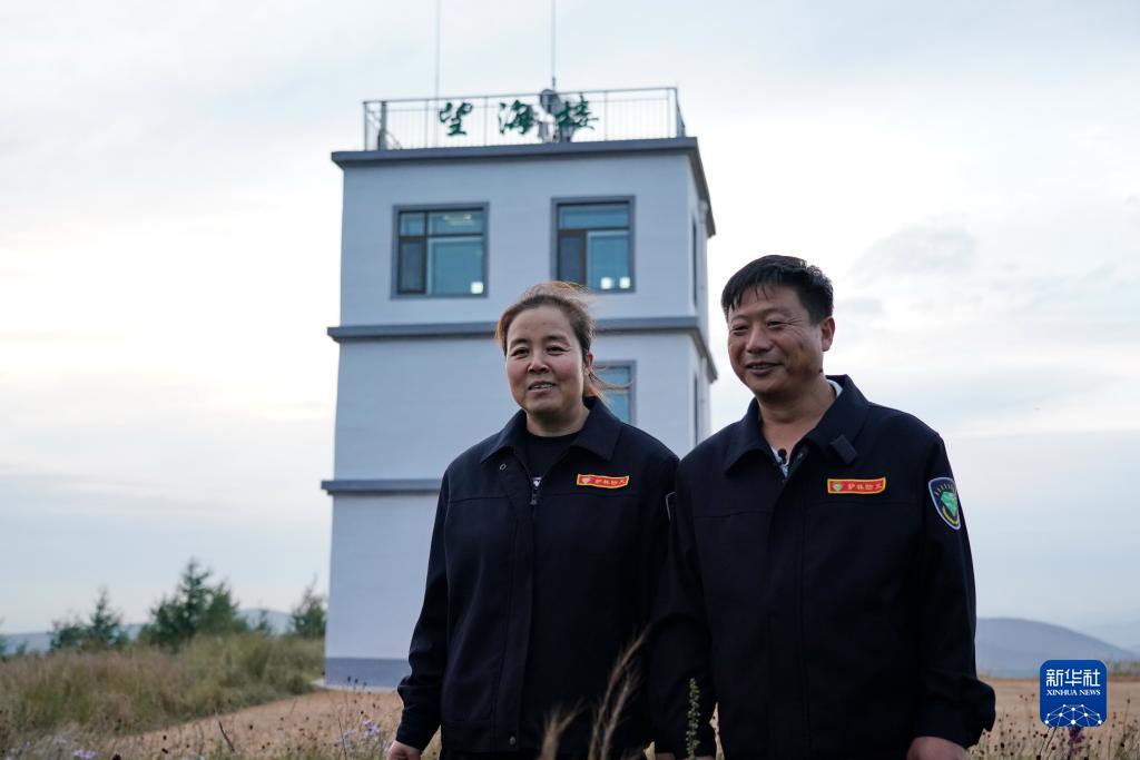 8月23日，刘军（右）、王娟夫妇在塞罕坝机械林场月亮山望海楼外。新华社记者 牟宇 摄