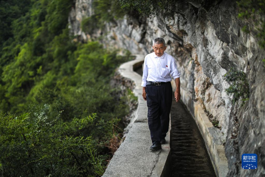 　　黄大发沿着修建在绝壁上的“大发渠”巡查（2018年8月11日摄）。新华社记者 刘续 摄