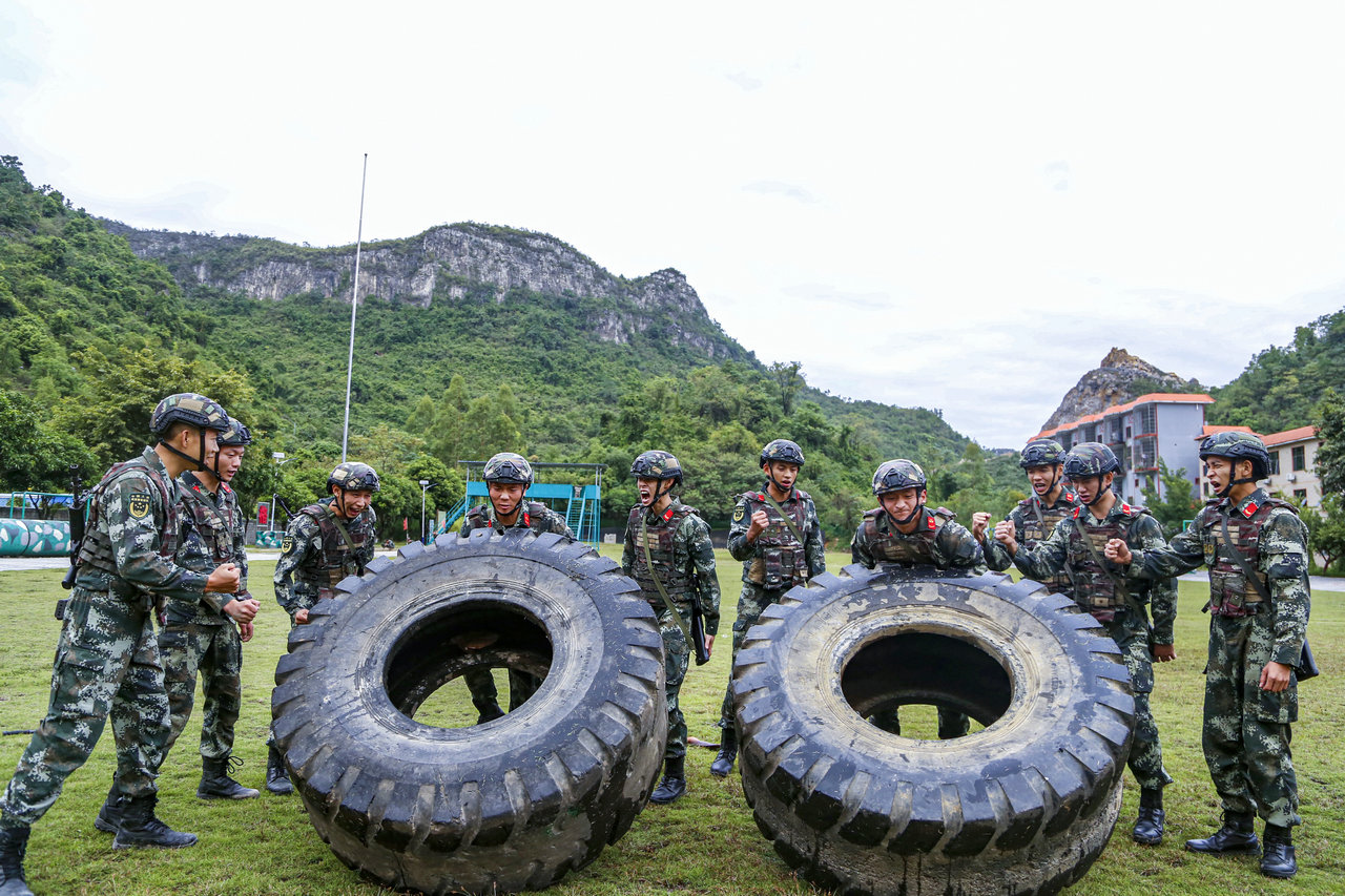 两名武警官兵正在进行翻轮胎力量比拼