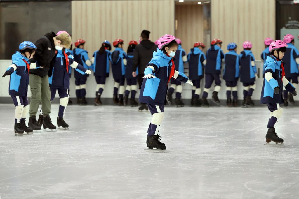  　　在上海新世界城的冰雪乐园，黄浦区卢湾一中心小学的学生在课堂上学习滑冰（2021年12月22日摄）。新华社记者 刘颖 摄