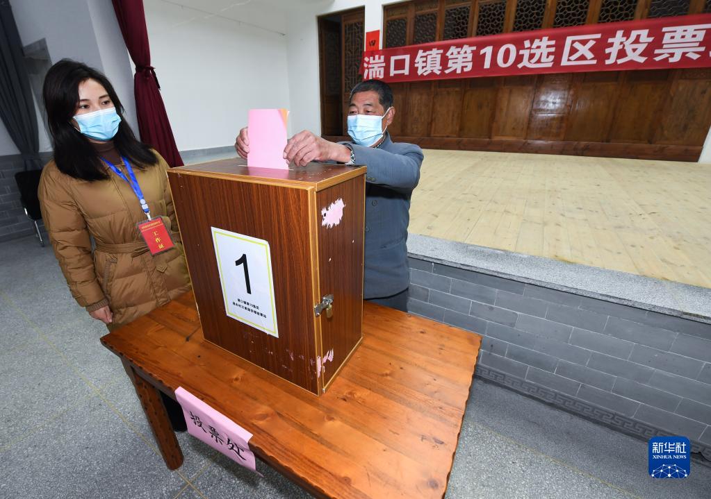 　　在设在浙江省杭州市临安区湍口镇迎丰村的一个基层人大换届选举投票站，村民在参加投票，村级监察联络员监票（2021年12月14日摄）。新华社记者 徐昱 摄