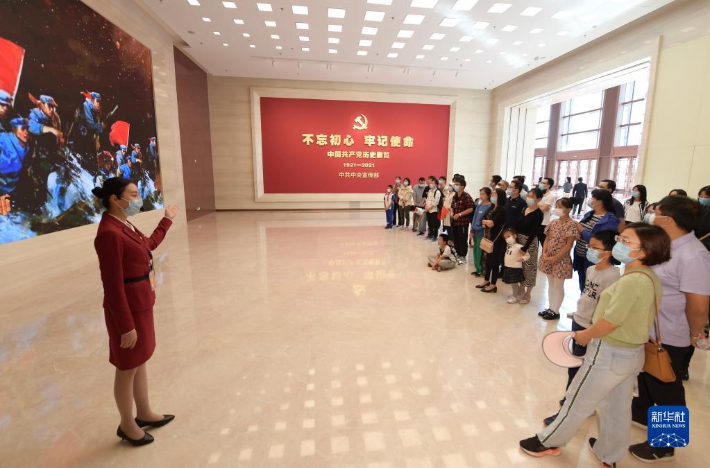 2021年10月1日，參觀者在中國共產黨歷史展覽館展廳聆聽工作人員講解。新華社記者 李賀 攝