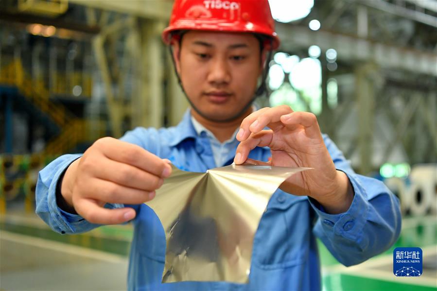　在位于山西的太钢集团，员工在展示用手撕开0.02毫米厚的超薄带状不锈钢（2019年5月24日摄）。新华社记者 曹阳 摄