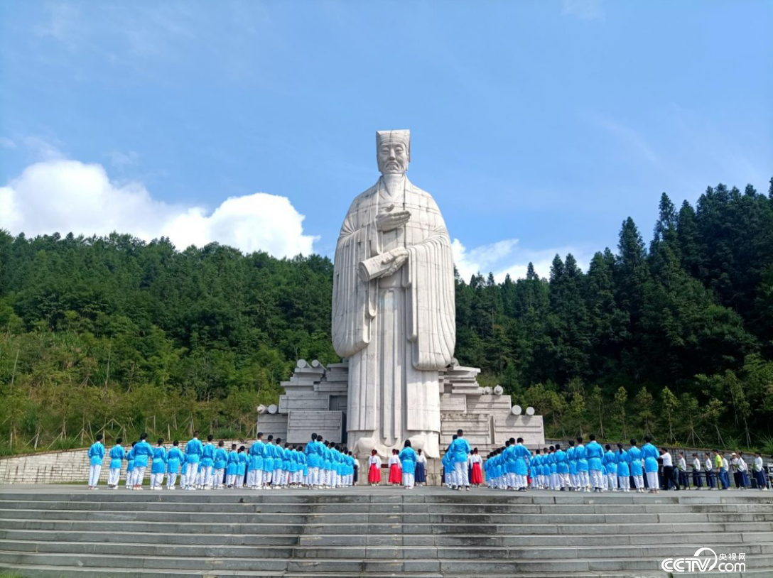 在五夫镇的朱子像前，学生们正在举行敬师礼。