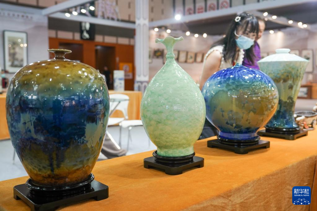 8月18日，观众在第二届中国工艺美术博览会参观特色陶瓷艺术展品。