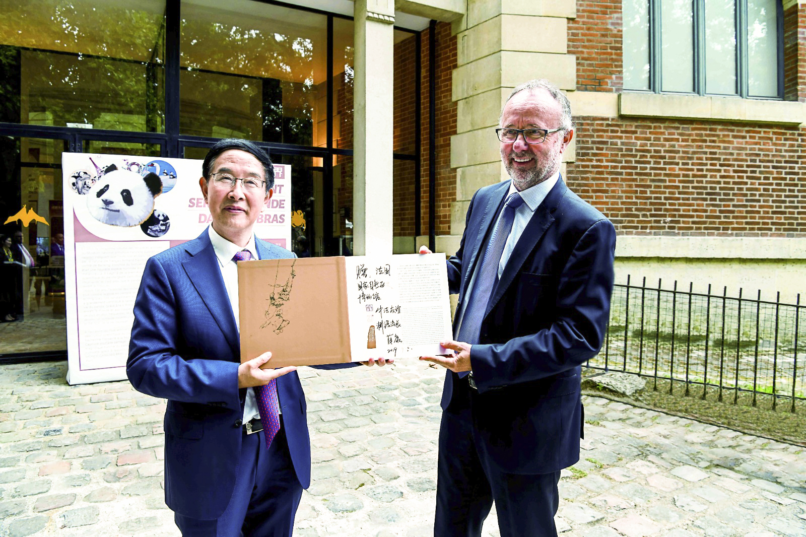 薛康（左）向法国国家自然历史博物馆馆长布鲁诺·戴维赠送金丝猴珍藏纪念册