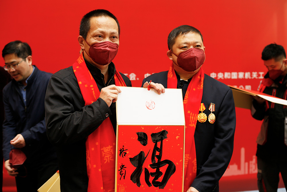 中国书法家协会副主席叶培贵现场向劳模代表送“福”字