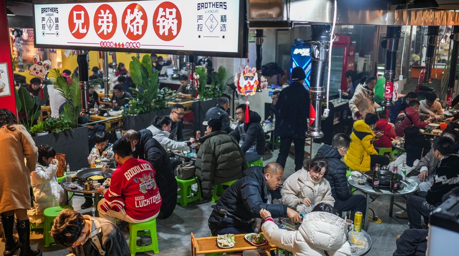People enjoy local food in Nanming District of Guiyang, southwest China’s Guizhou Province, Jan. 23, 2023. (Xinhua/Tao Liang)
