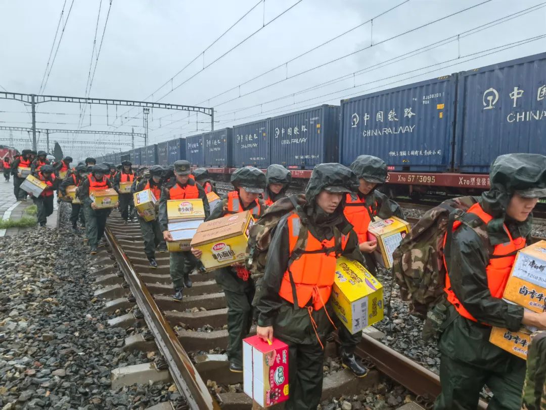 北京总队官兵齐心协力为火车站受困旅客运送物资。