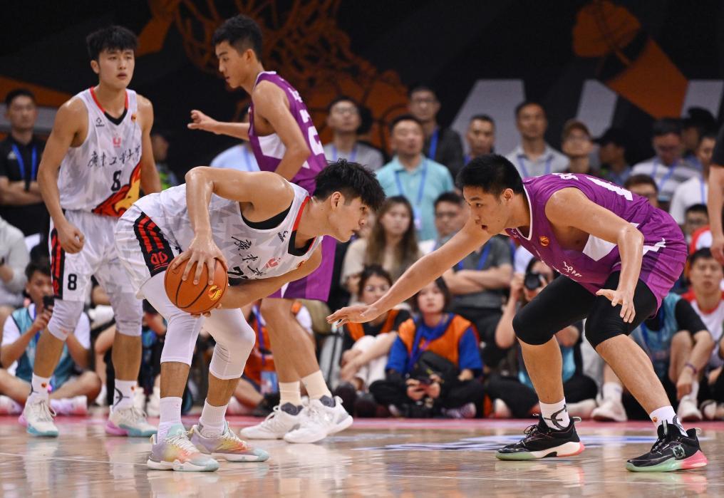 6月18日，清华大学队球员刘庆闻（右）在比赛中防守广东工业大学队球员陈国豪（前左）。新华社记者 胥冰洁 摄