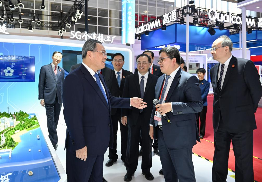 Chinese Premier Li Qiang talks with a staff member of an exhibitor at the exhibition hall before the opening ceremony of the first China International Supply Chain Expo in Beijing, capital of China, Nov. 28, 2023. (Xinhua/Rao Aimin)