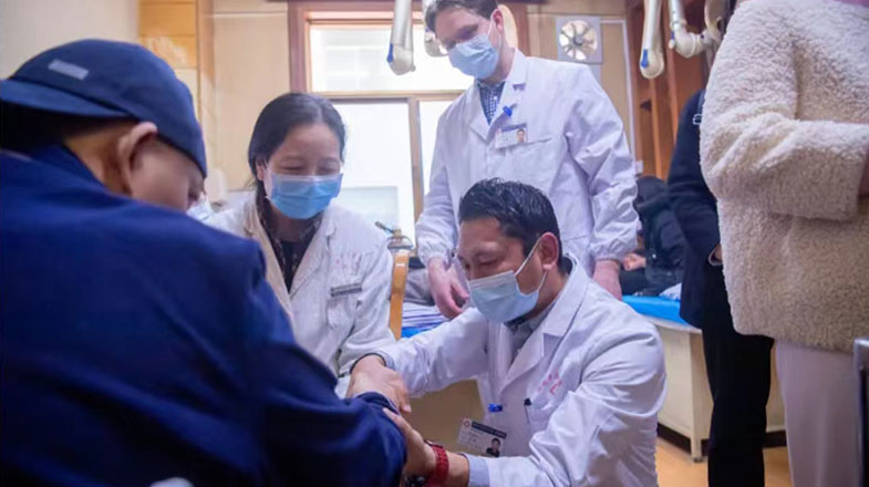 土登巴桑(中间)在导师章薇指导下为患者做腕关节手诊