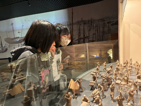 來自海南的中學生在泉州海外交通史博物館觀賞“迎番貨”雕塑。人民網記者 金慧慧攝