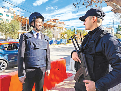 图为袁泉（左）同巴勒斯坦安保人员协调安全防范措施。