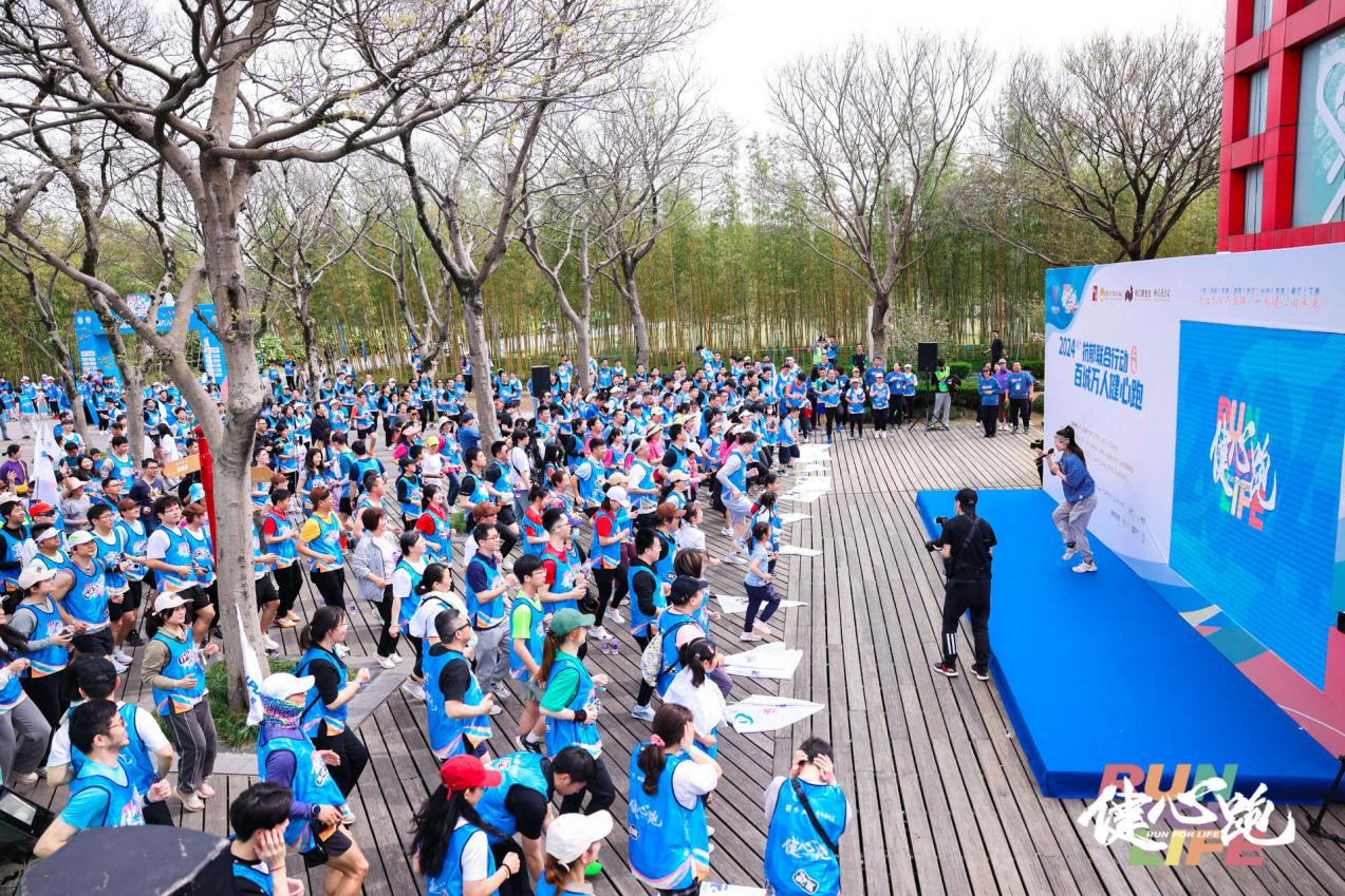 3月30日，“百城万人健心跑”线下活动上海站，跑者正在运动达人带领下进行跑前热身。
