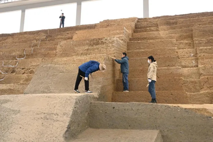 考古工作者在考古现场填土夯层划地层线