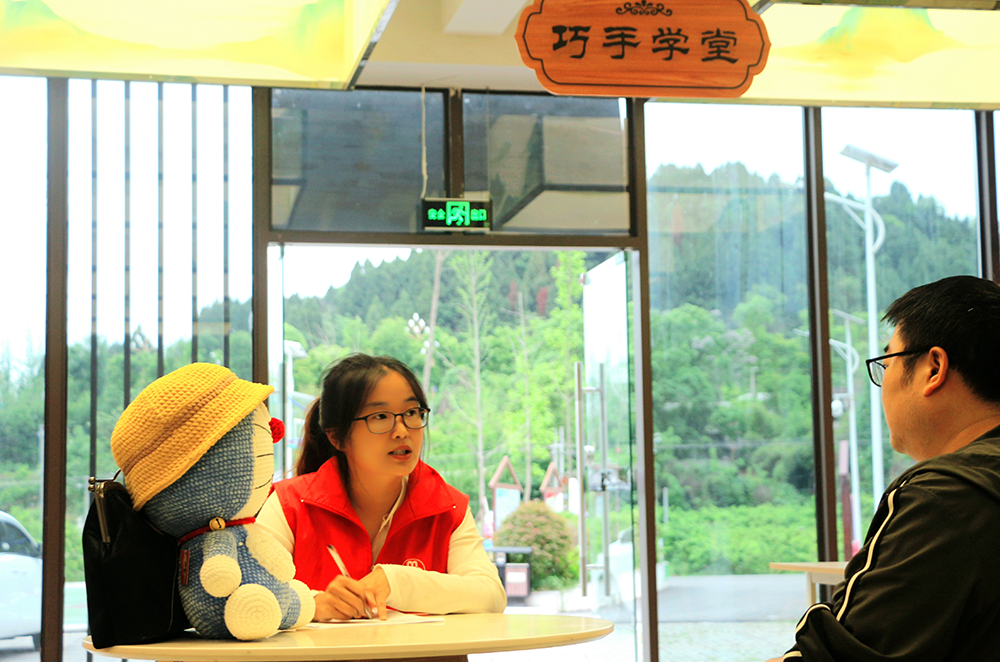 连山村妇联主席雷玉兰（左）在“巧手工坊”内商谈项目