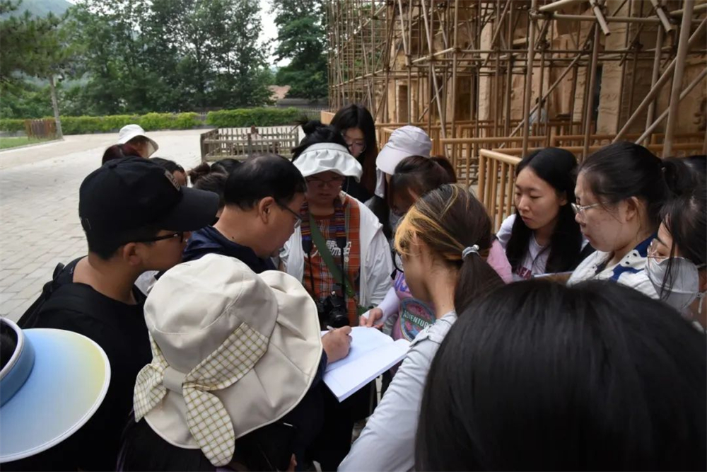 在北石窟寺调研现场，魏文斌为学生们示范平、剖面图的绘制（图片来源于兰州大学新闻网）