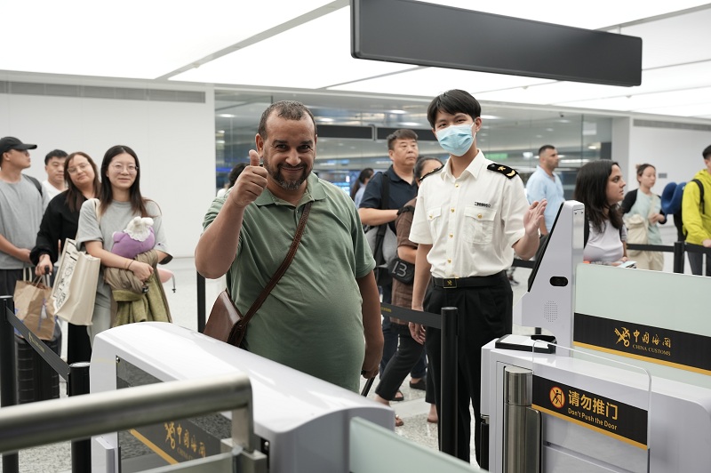 杭州海关所属杭州萧山机场海关关员引导国外旅客通过一体化智能闸机进行通关。周雨亮摄