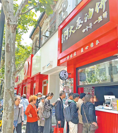 “阿大葱油饼”店铺前排起长队。