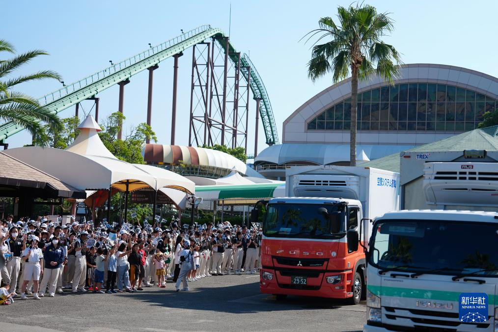 6月28日，工作人员与当地民众在日本和歌山县冒险世界游乐园外目送运输大熊猫的卡车离开。新华社记者 贾浩成 摄